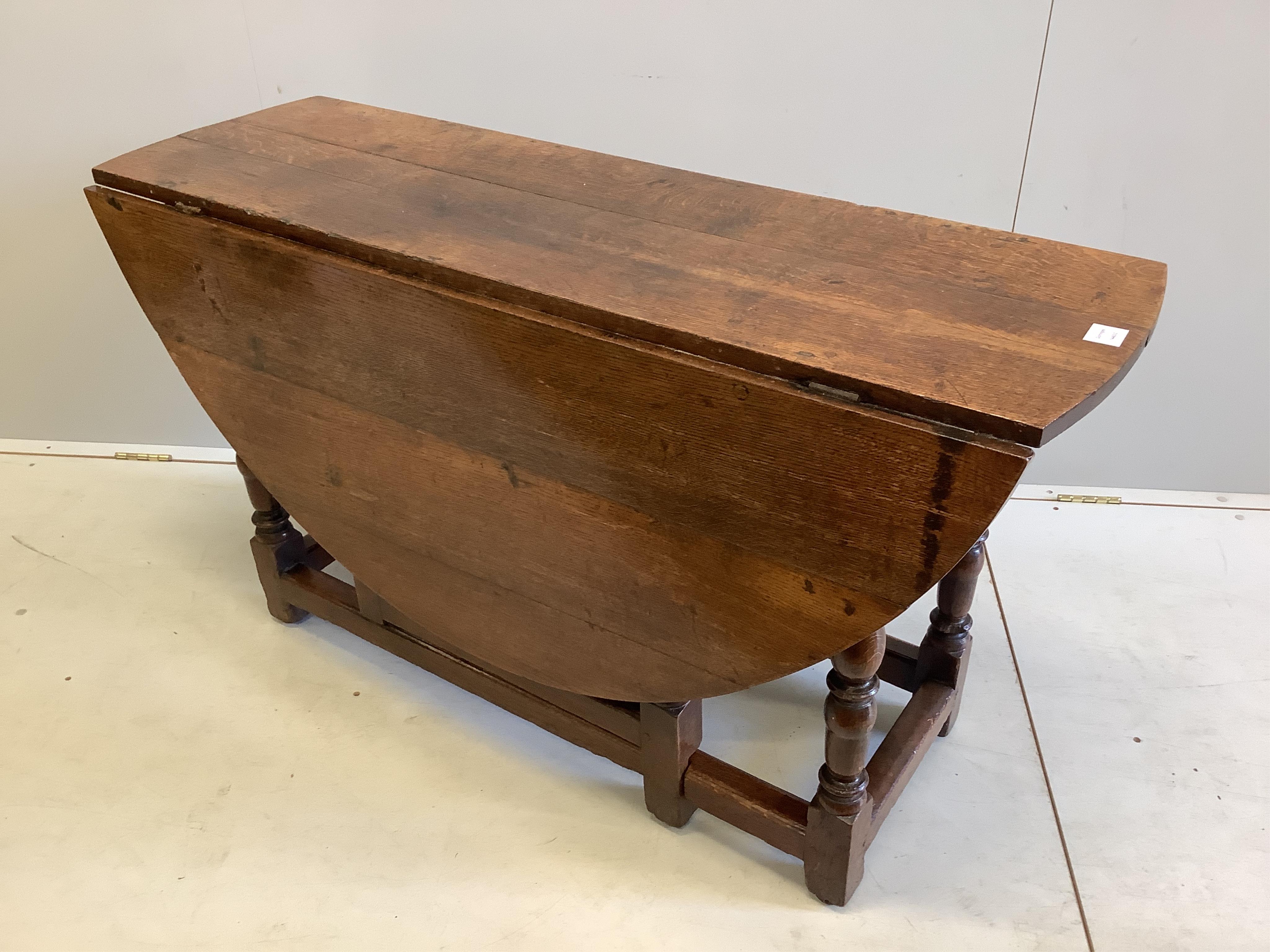An 18th century oval oak gateleg dining table, width 139cm extended, depth 127cm, height 70cm. Condition - good